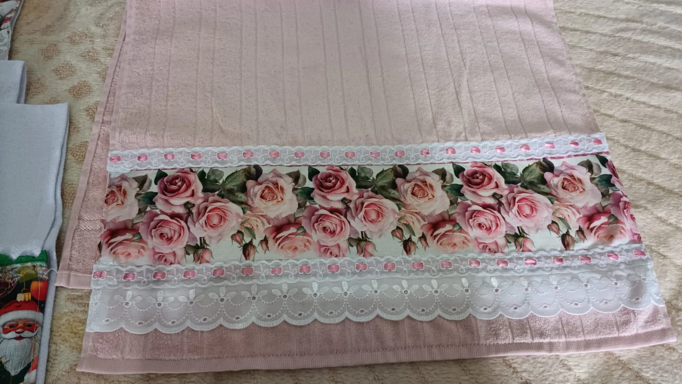 Toalha rosa com barrado de tecido estampado de rosas e renda branca, costurados pela vó